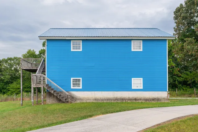 an aerial view of residential houses with outdoor space and trees