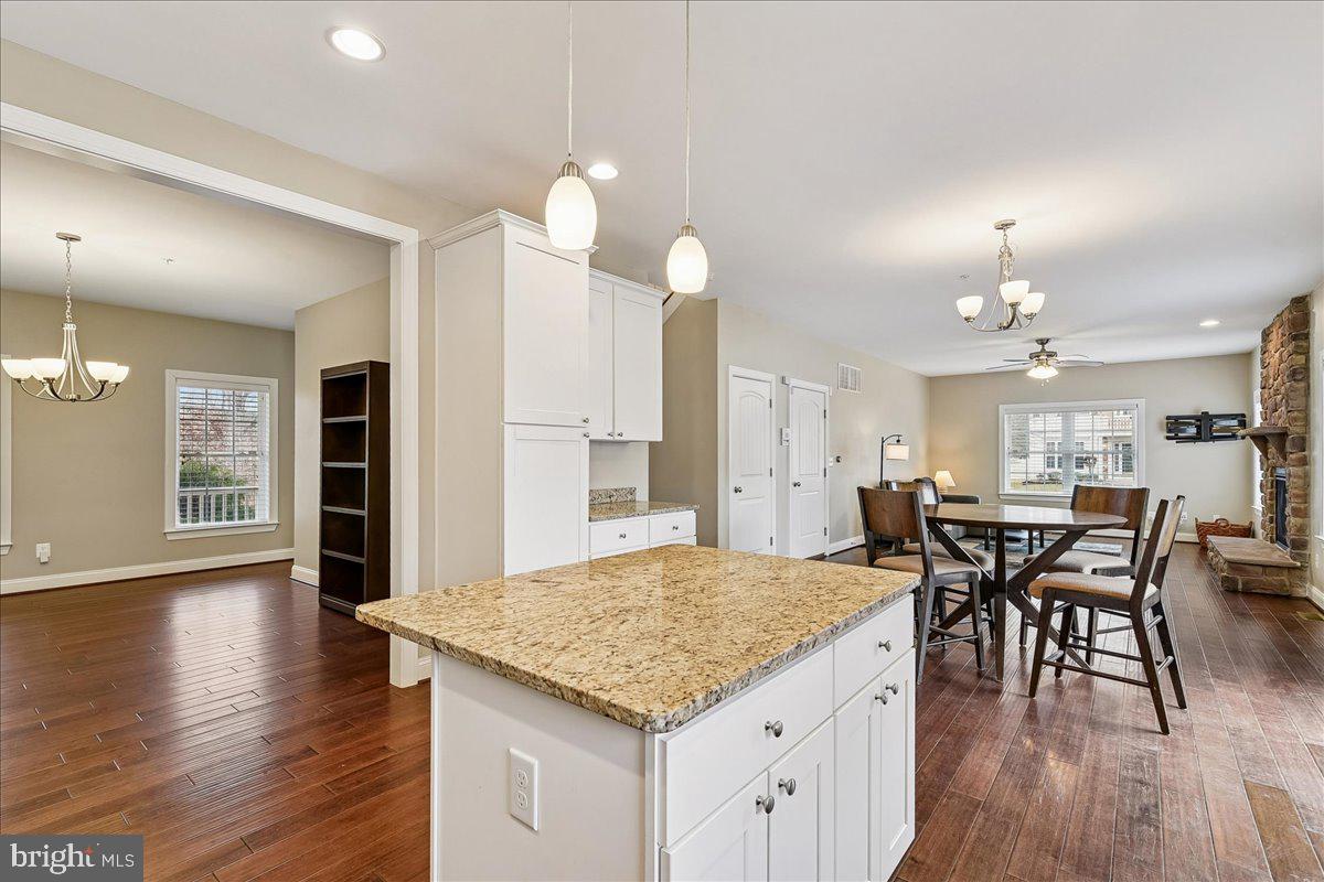 7526 Gilley Terrace Rosedale, MD 21237 - Photo 12 of 43 an open kitchen with granite countertop kitchen island wooden floor center island and stainless steel appliances