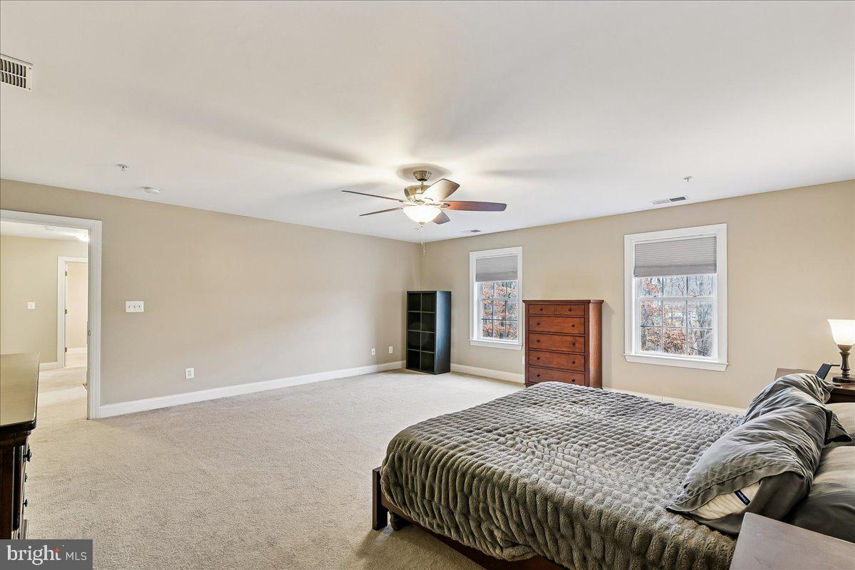 7526 Gilley Terrace Rosedale, MD 21237 - Photo 25 of 43 a spacious bedroom with a large bed and a chandelier