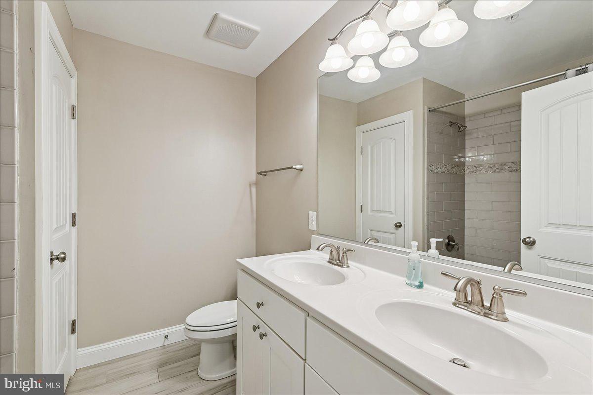 7526 Gilley Terrace Rosedale, MD 21237 - Photo 35 of 43 a bathroom with a toilet a sink and a large mirror