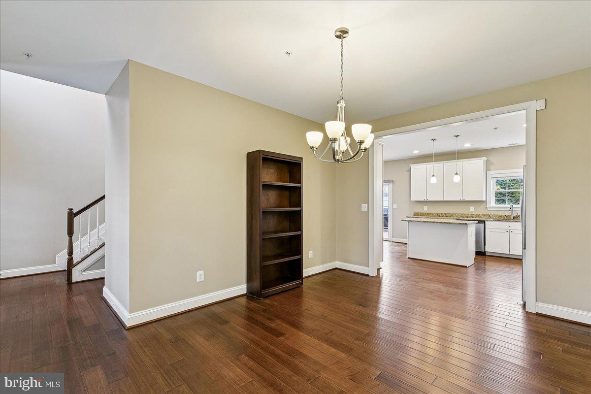 7526 Gilley Terrace Rosedale, MD 21237 - Photo 10 of 43 a view of a big room with wooden floor chandelier and windows