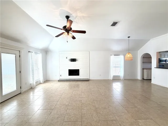 a view of a livingroom with a ceiling fan a kitchen space and a window