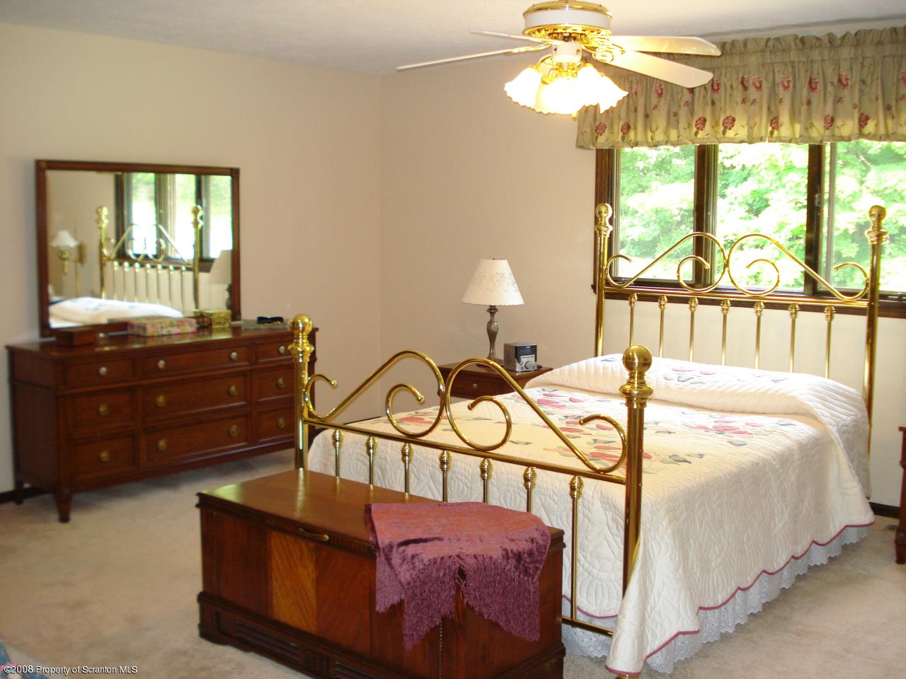 72 Memory Lane Moscow, PA 18444 - Photo 25 of 34 a bedroom with a bed and a chandelier