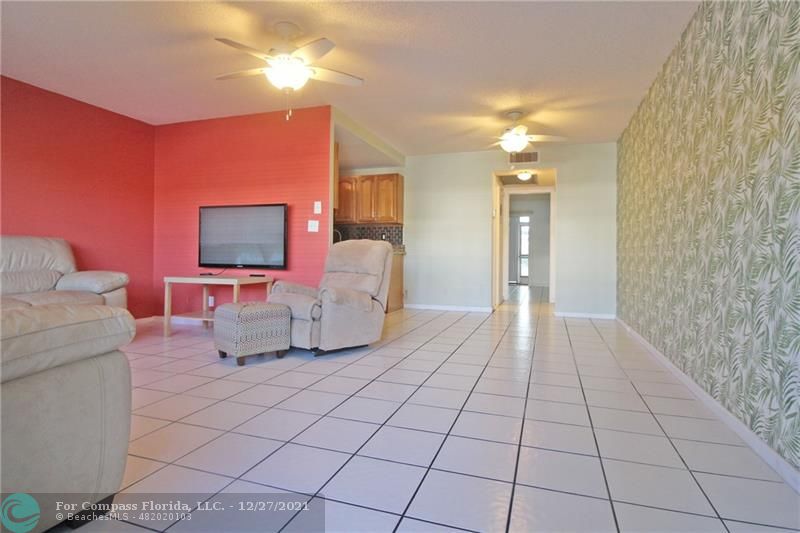 1045 Cambridge C, Unit 1045 Deerfield Beach, FL 33442 - Photo 1 of 60 a living room with furniture and a flat screen tv