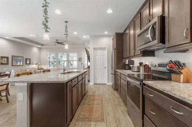 a kitchen with stainless steel appliances granite countertop a sink and cabinets