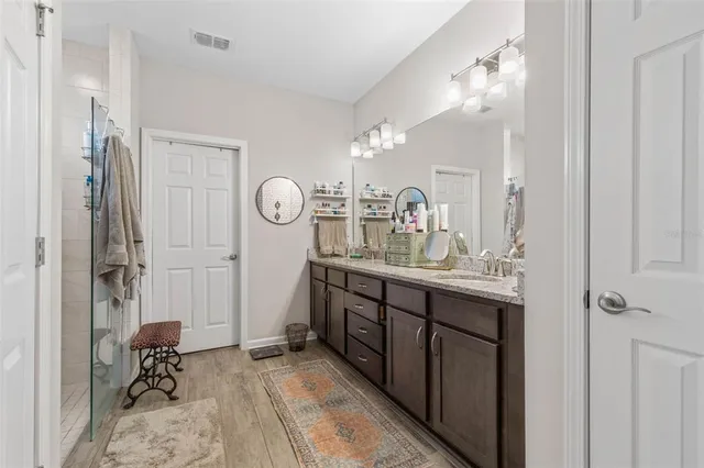 a bathroom with a double vanity sink mirror and shower