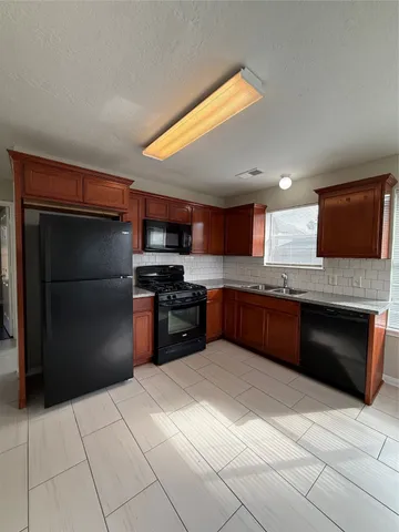 a kitchen with stainless steel appliances granite countertop a refrigerator and a stove