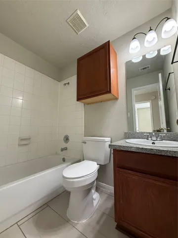 a bathroom with a granite countertop toilet sink and mirror
