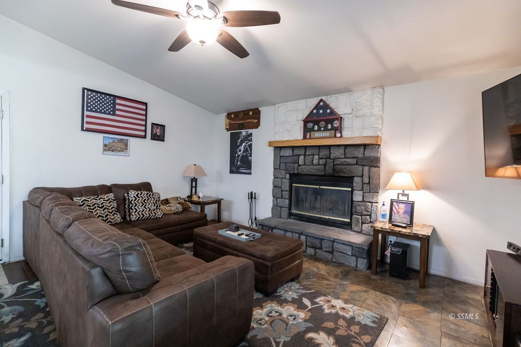 324 East Upjohn Avenue Ridgecrest, CA 93555 - Photo 13 of 35 a living room with furniture a fireplace and a flat screen tv