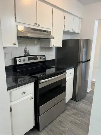 a kitchen with stainless steel appliances a stove a refrigerator and cabinets