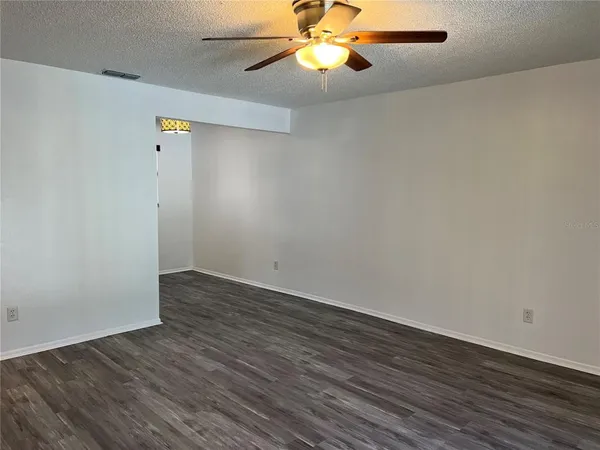 a view of an empty room with wooden floor