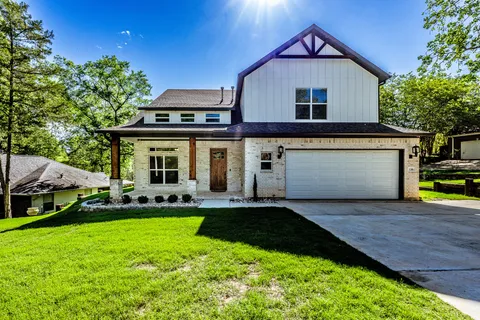 a front view of a house with a yard and trees