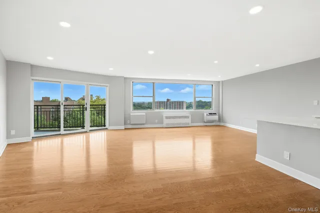 a view of an empty room with wooden floor and a floor to ceiling window