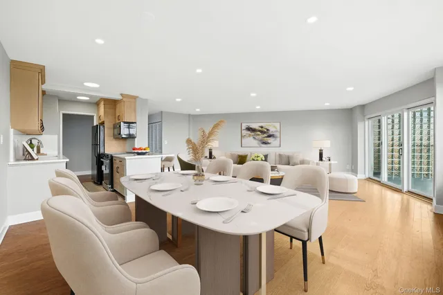 a living room with stainless steel appliances kitchen island furniture and a wooden floor