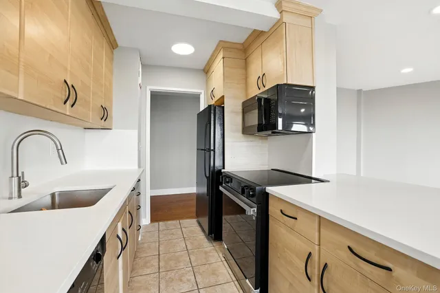 a kitchen with stainless steel appliances granite countertop a sink and a refrigerator