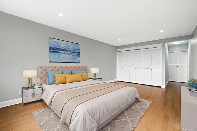 a spacious bedroom with a bed and painting on the wall