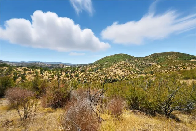 a view of a large mountain with mountains in the background