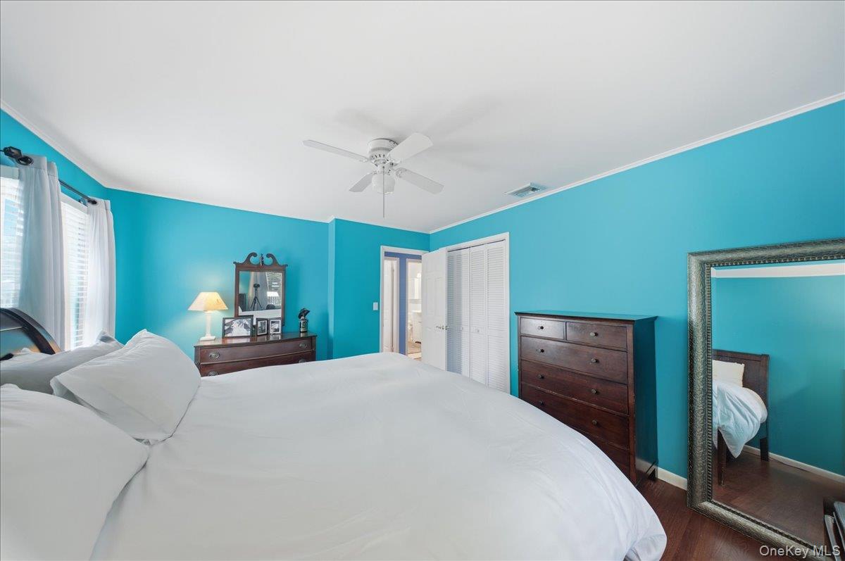 10 Graham Road Hampton Bays, NY 11946 - Photo 11 of 26 a bedroom with a bed and a chandelier