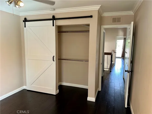 a view of a room with wooden floor and a door