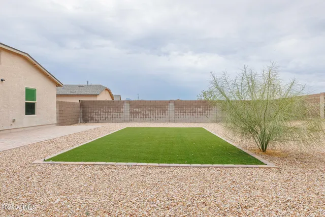 a view of backyard with swimming pool and seating area