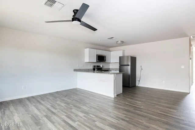 a view of kitchen with stainless steel appliances a refrigerator and a stove top oven