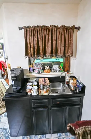 a kitchen with a sink and a stove with wooden floor