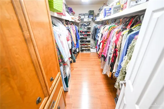 a view of walk in closet with clothes