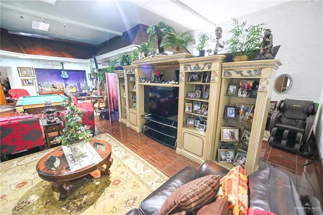 a picture of a living room with a rug and a book shelf