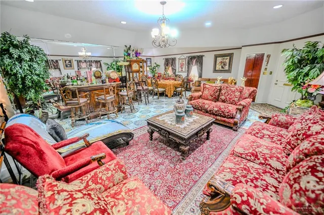 a living room with furniture a chandelier and a rug