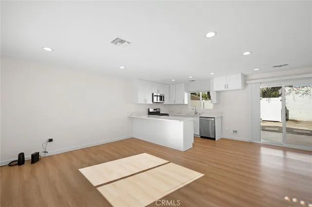 a kitchen with a refrigerator and white cabinets