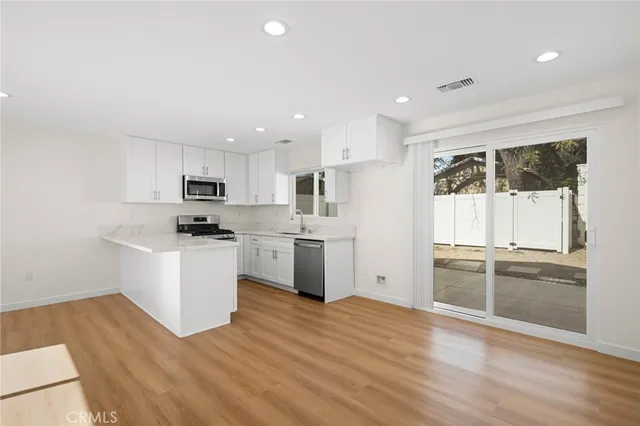 a kitchen with granite countertop white cabinets and white appliances