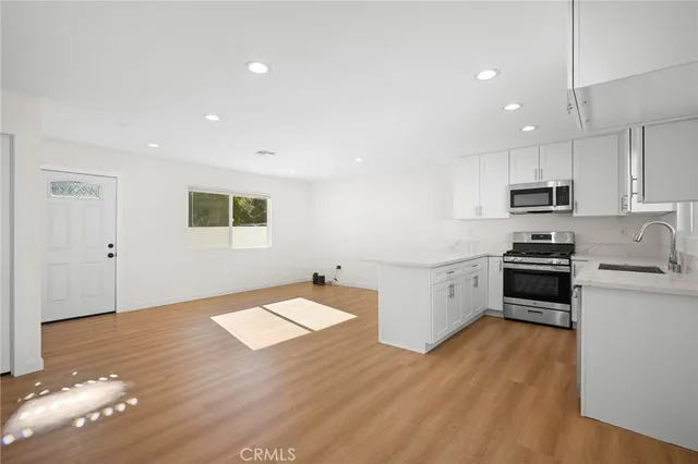 a kitchen with granite countertop a stove cabinets and wooden floor