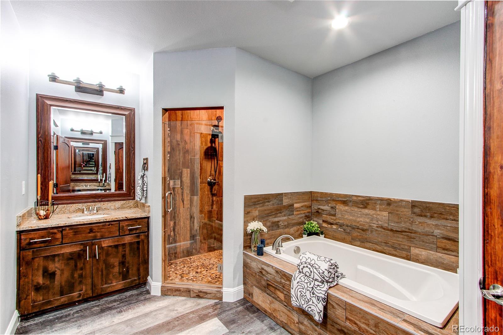 6001 Xmore Road Byers, CO 80103 - Photo 16 of 48 a bathroom with a bathtub and a sink