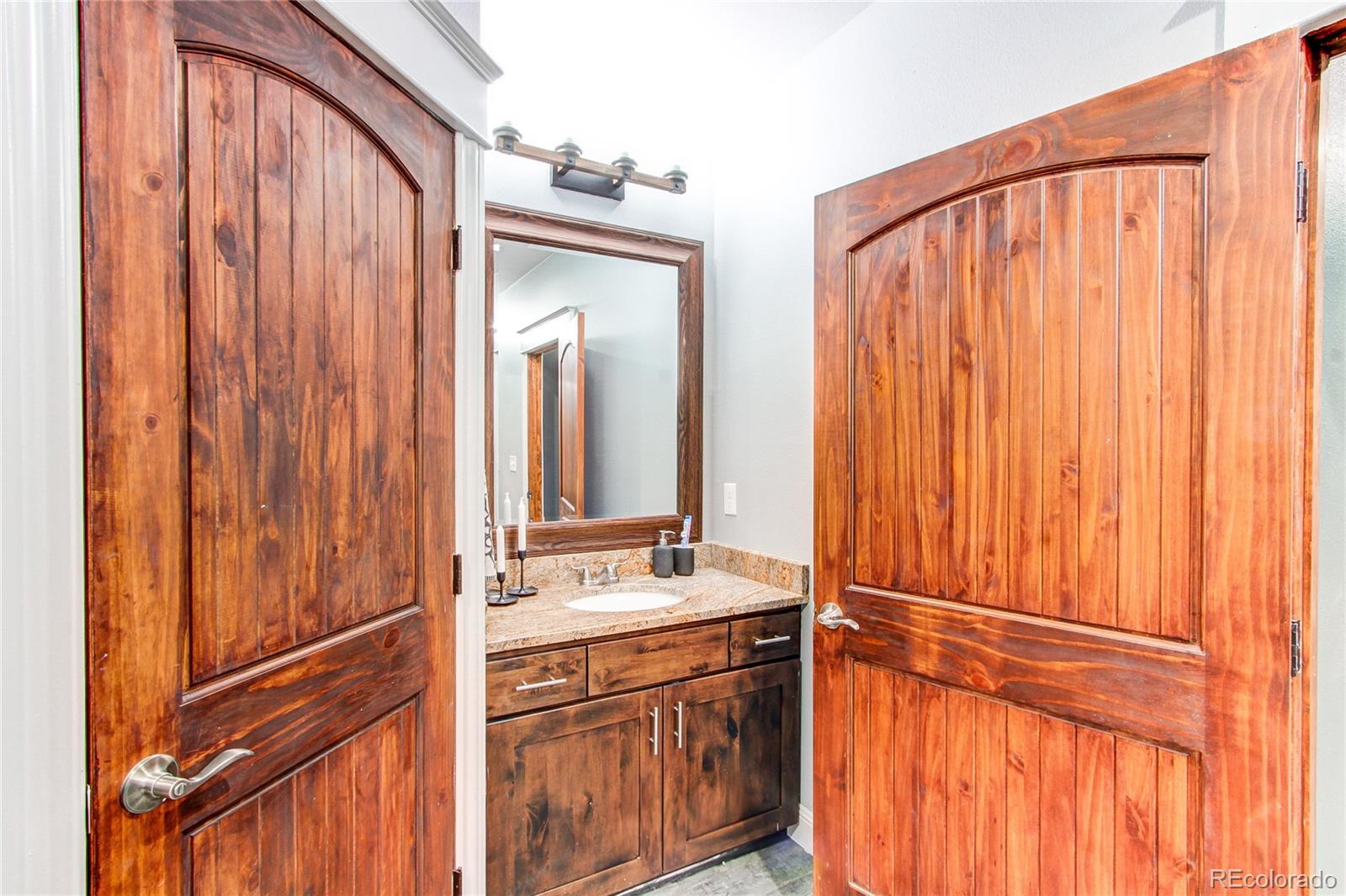 6001 Xmore Road Byers, CO 80103 - Photo 18 of 48 a bathroom with a sink and a mirror