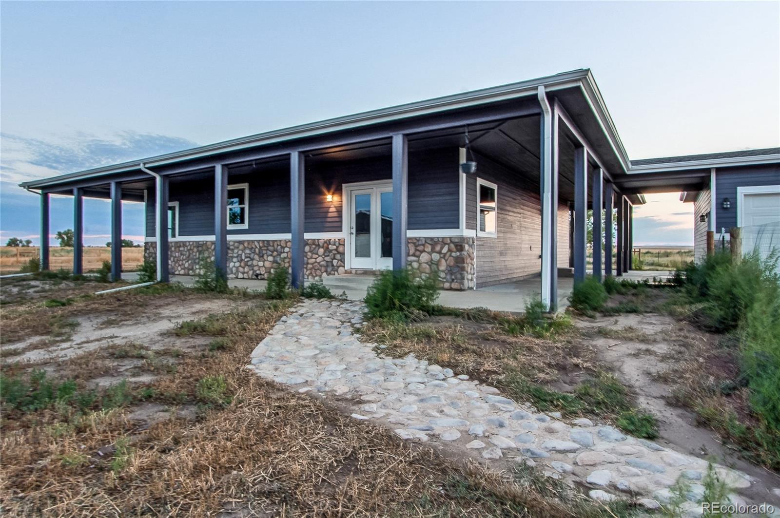 6001 Xmore Road Byers, CO 80103 - Photo 2 of 48 a front view of a house with garden