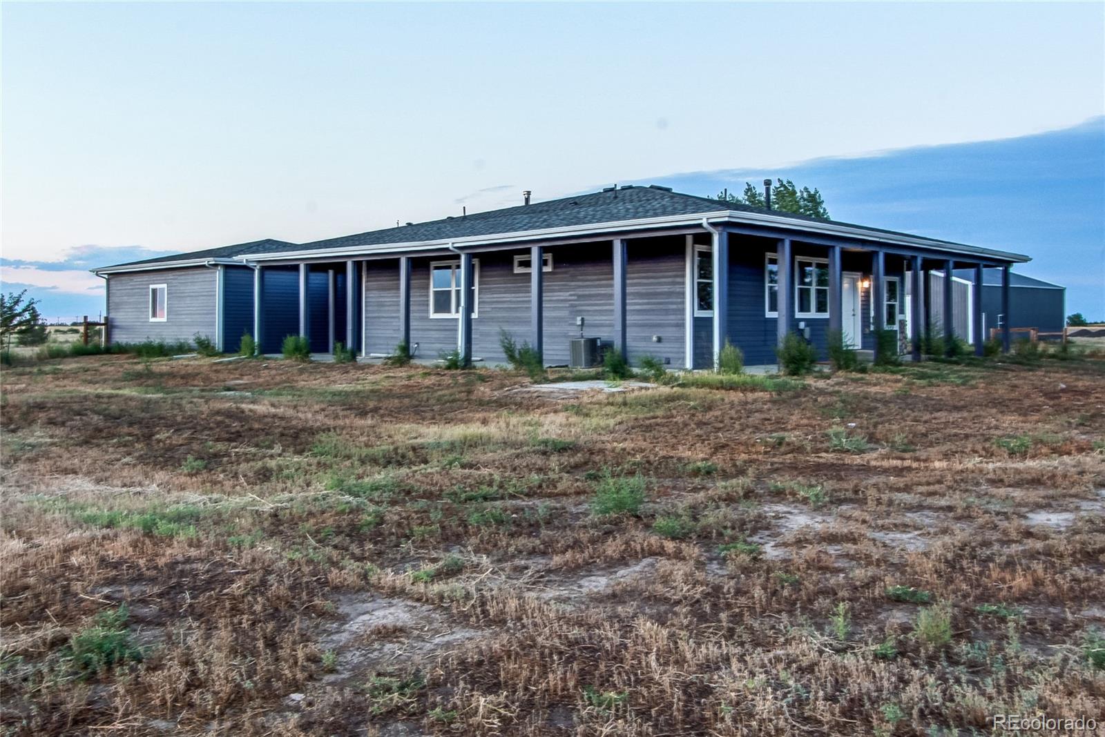 6001 Xmore Road Byers, CO 80103 - Photo 3 of 48 a big yard with large trees and wooden fence