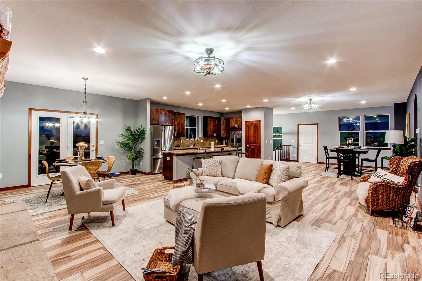 6001 Xmore Road Byers, CO 80103 - Photo 4 of 48 a living room with furniture kitchen view and a chandelier
