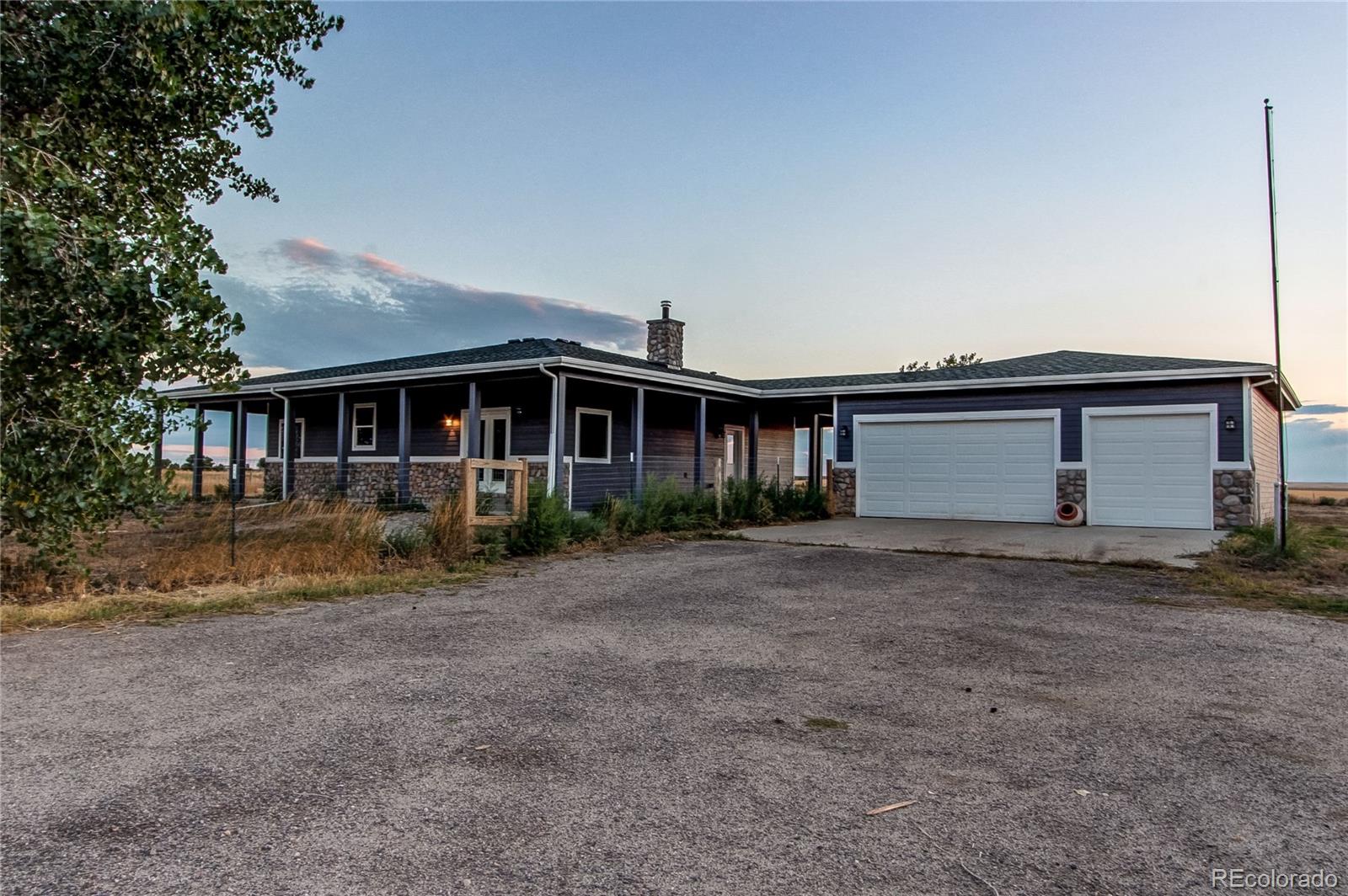 6001 Xmore Road Byers, CO 80103 - Photo 46 of 48 a view of a yard in front of a house with large trees