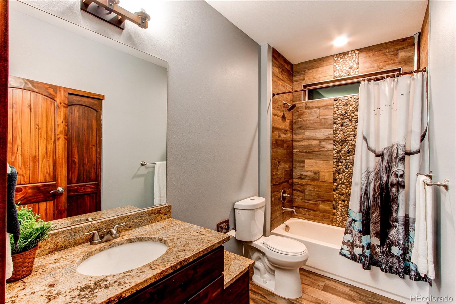 6001 Xmore Road Byers, CO 80103 - Photo 7 of 48 a bathroom with a granite countertop sink toilet and shower