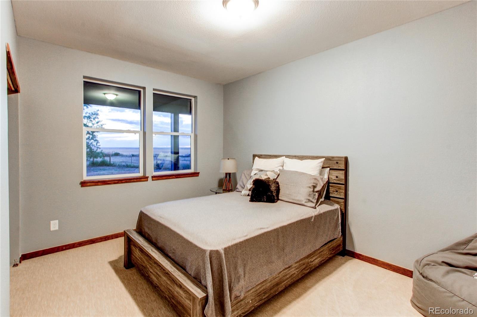 6001 Xmore Road Byers, CO 80103 - Photo 9 of 48 a bed sitting in a bedroom next to a window