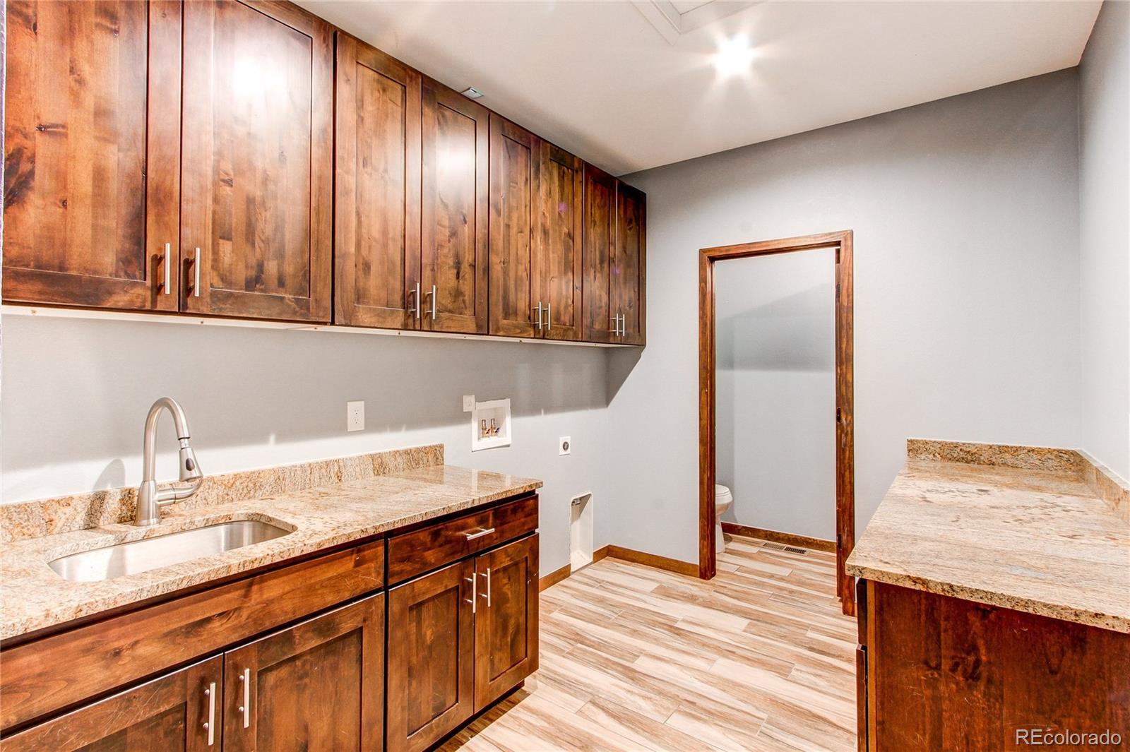 6001 Xmore Road Byers, CO 80103 - Photo 10 of 48 a kitchen with stainless steel appliances granite countertop wooden cabinets a sink and dishwasher