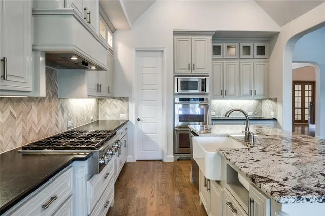 a kitchen with stainless steel appliances granite countertop a stove and a sink