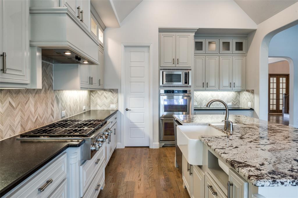 10482 Tobias Lane Frisco, TX 75033 - Photo 15 of 40 a kitchen with stainless steel appliances granite countertop a stove and a sink
