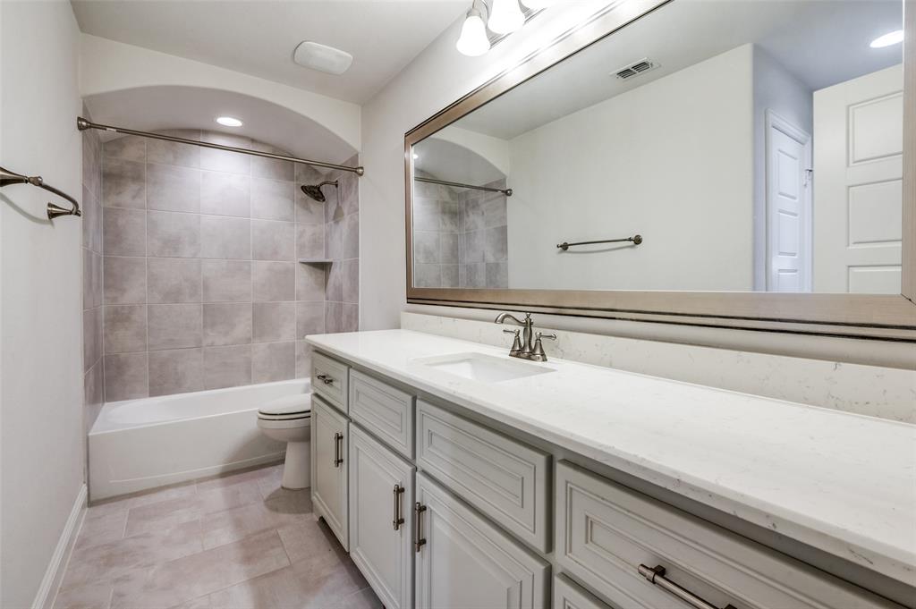 10482 Tobias Lane Frisco, TX 75033 - Photo 22 of 40 a bathroom with a double vanity sink toilet mirror and bathtub