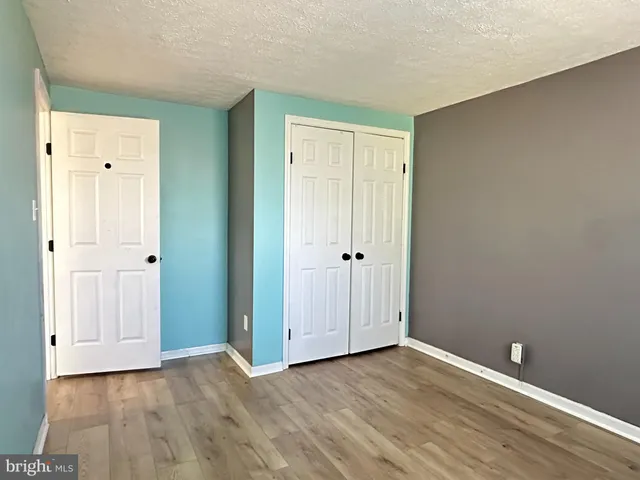 a view of an empty room and wooden floor