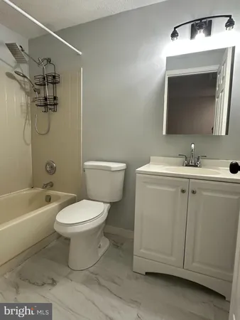 a bathroom with a toilet sink vanity tub and mirror