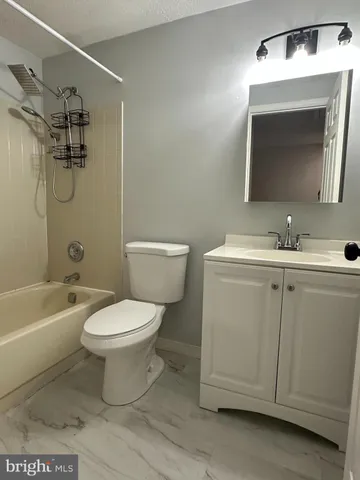a bathroom with a toilet sink vanity tub and mirror