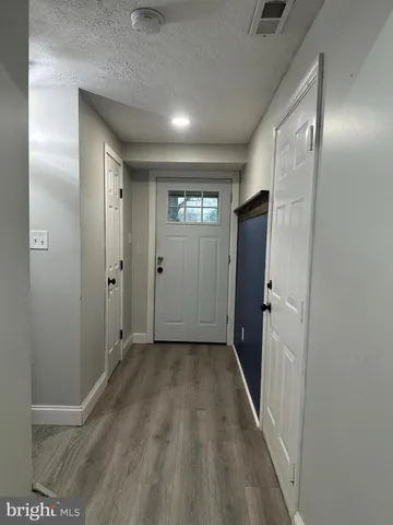 a view of a big room with wooden floor and windows