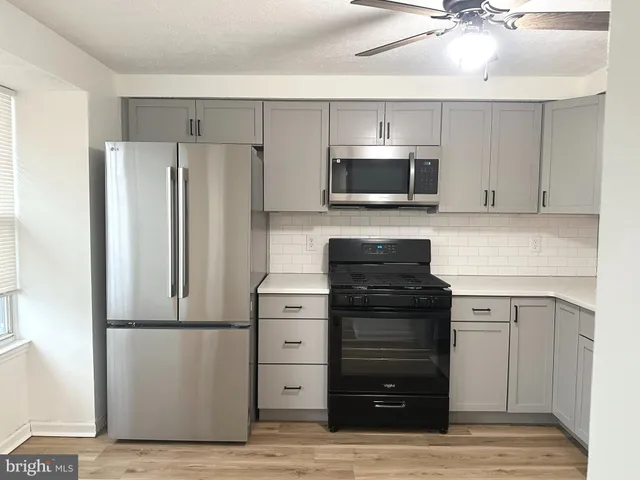 a kitchen with a refrigerator stove and white cabinets