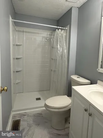 a bathroom with a toilet and a shower